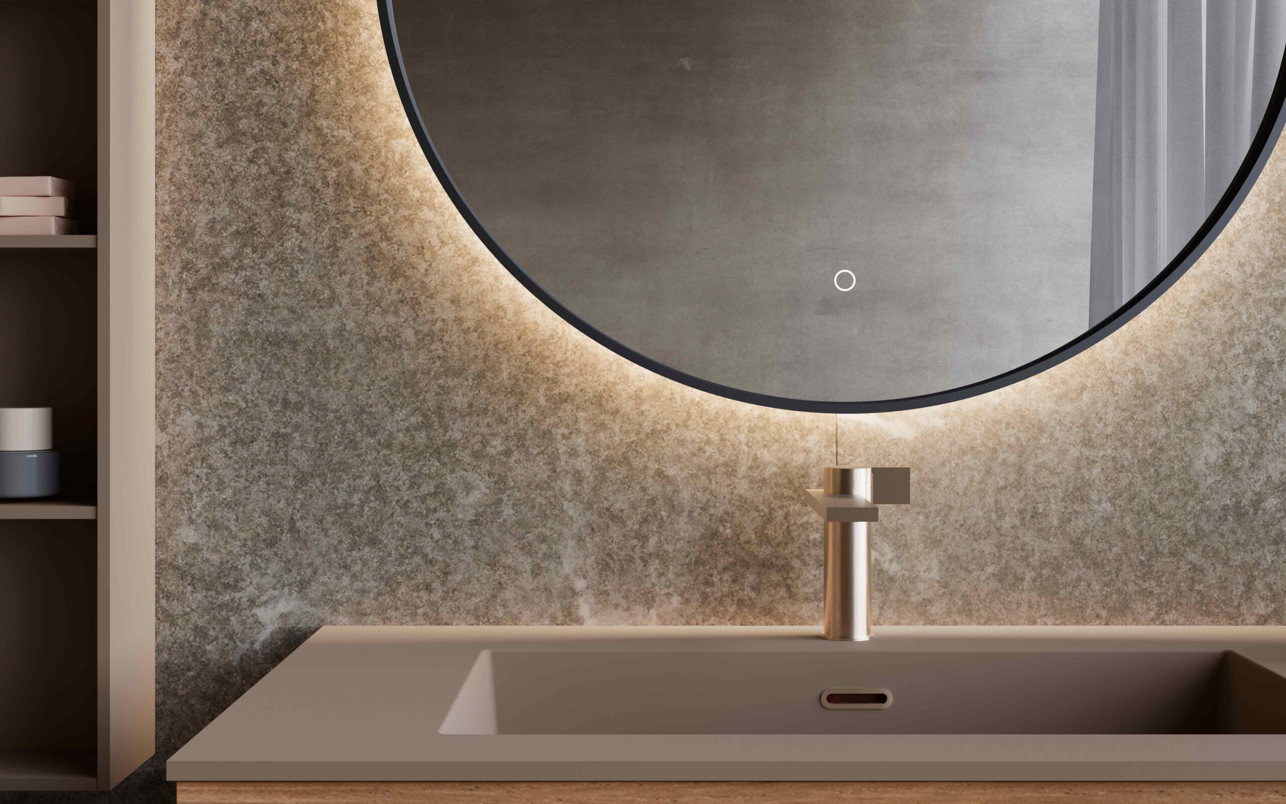 Specchio tondo con cornice nera e retroilluminazione calda su parete effetto pietra, sopra un lavabo color tortora con rubinetteria satinata
