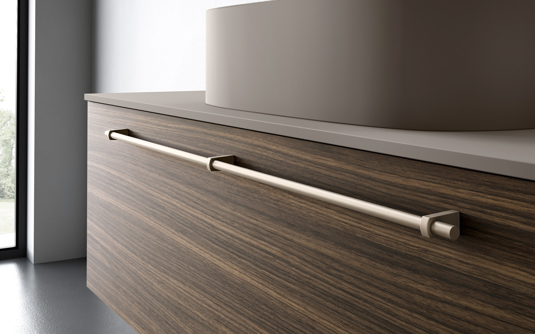 Dark wood bathroom cabinet with long handle in satin gold finish, smooth dove grey top and modern cylindrical washbasin.