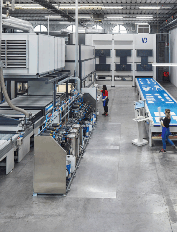 Reparto produttivo Azzurra Group con impianti industriali automatizzati per la lavorazione e la finitura di componenti per l’arredo bagno, in un ambiente moderno e tecnologicamente avanzato.