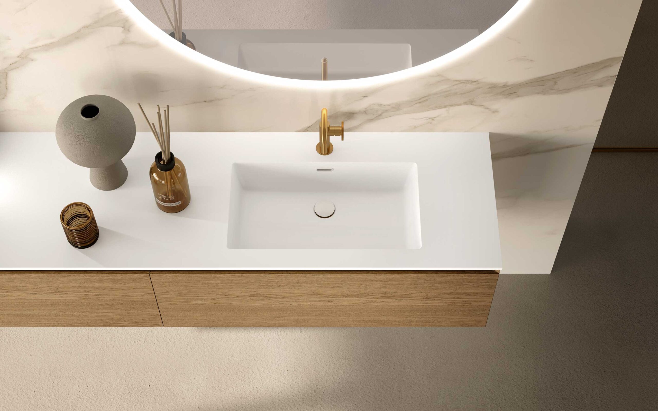 Lavabo integrato bianco con base in legno e rubinetto dorato, specchio tondo sullo sfondo
