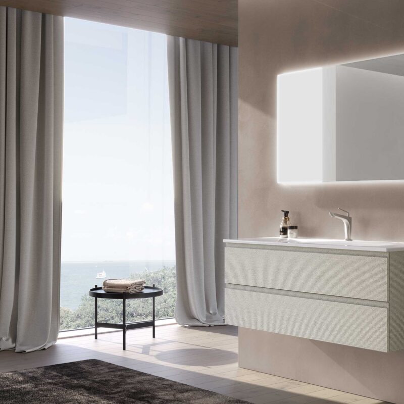 Mobile bagno sospeso bianco a due cassetti con lavabo integrato e specchio LED rettangolare, ambiente con vista mare