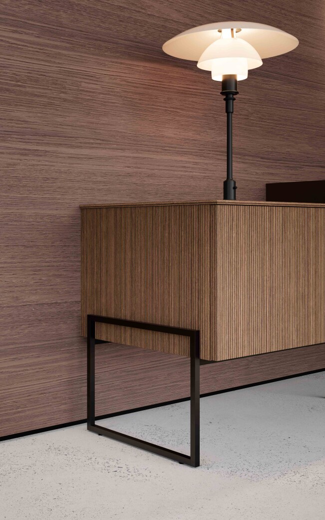 Mobile bagno sospeso con frontali in Dekorativo 3D effetto rigato, struttura in metallo nero e lampada d'appoggio in un ambiente dal design contemporaneo.