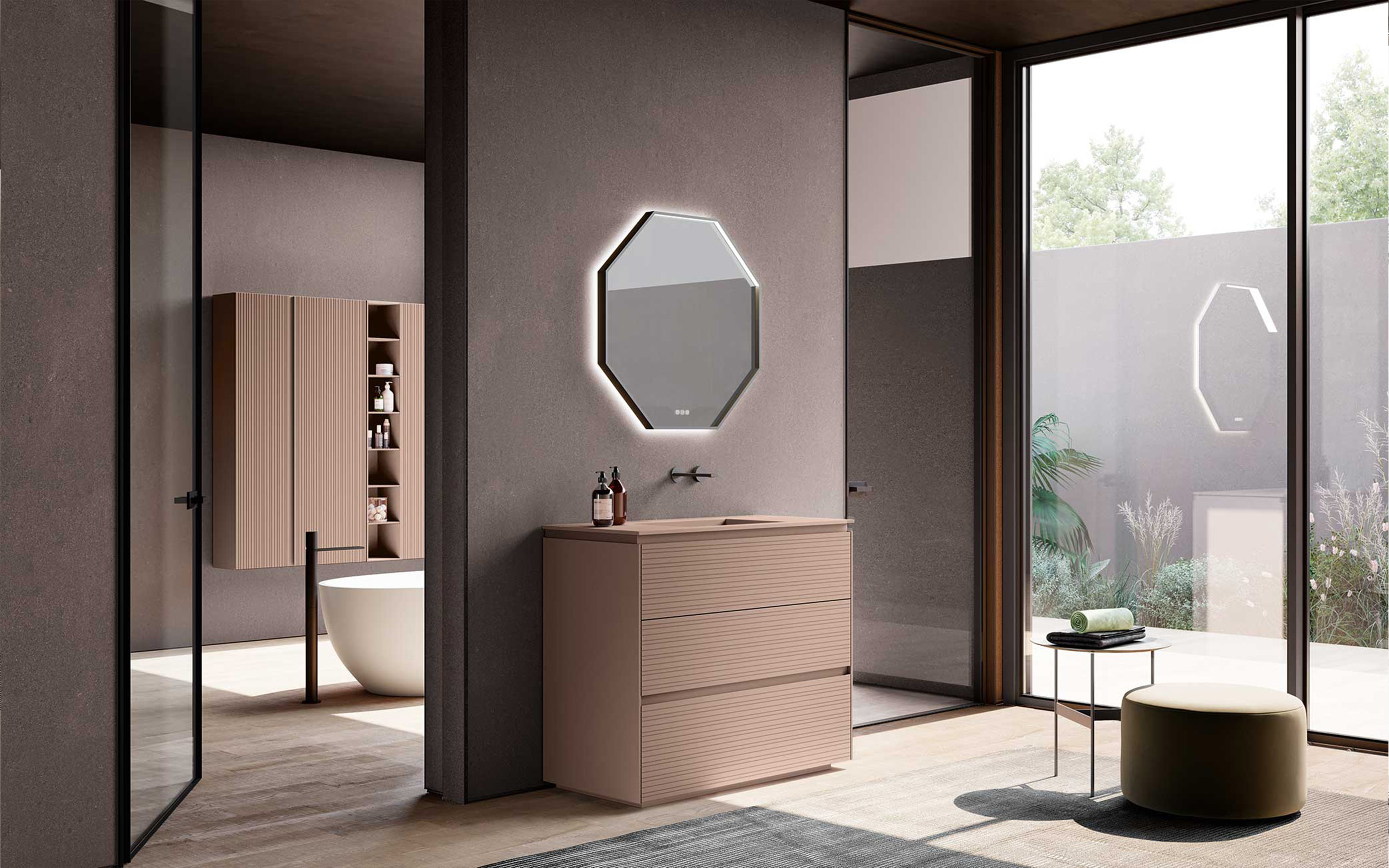 Bagno contemporaneo con mobile Azzurra Lime 2.0 sulle tonalità del rosa con frontali in cannettato orizzontale, lavabo integrato, specchio ottagonale retroilluminato, colonna contenitiva coordinata e grandi vetrate che illuminano l'ambiente.
