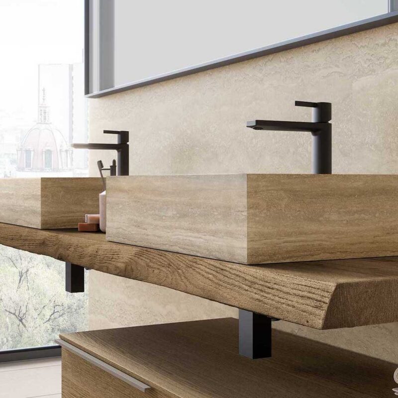 Doppio lavabo d’appoggio rettangolare su piano sospeso in legno, con rubinetteria nera in un bagno moderno.